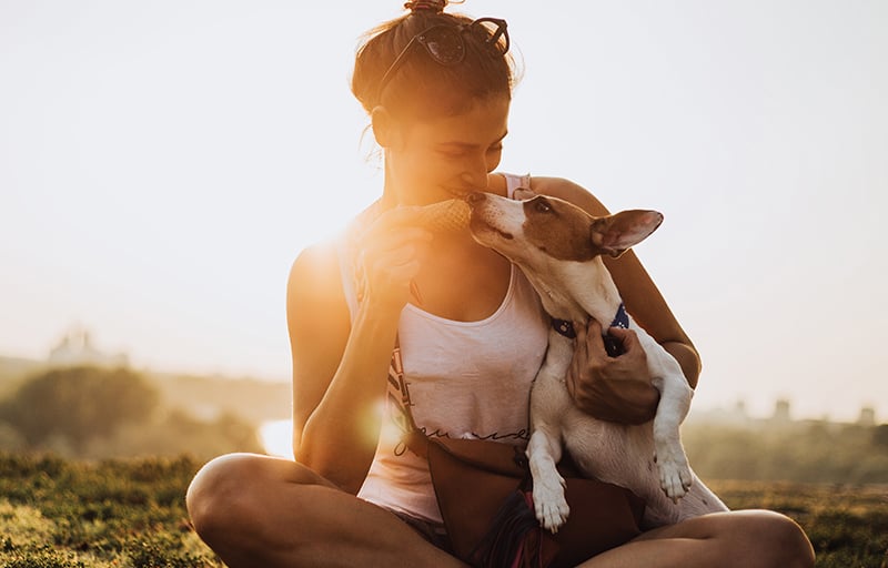 A woman offering her dog a treat