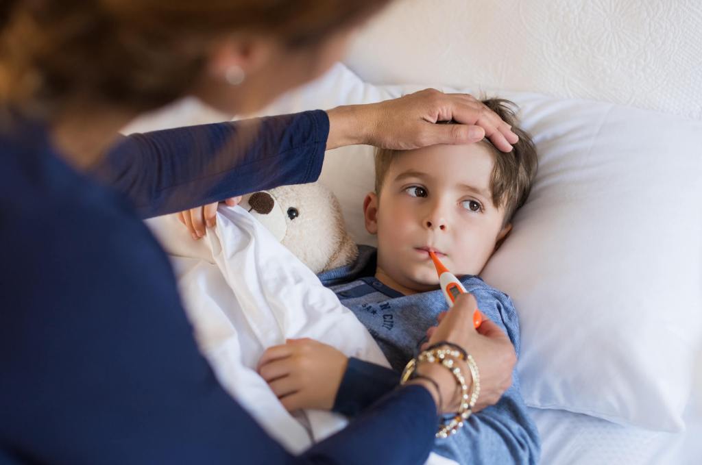 ill boy with thermometer