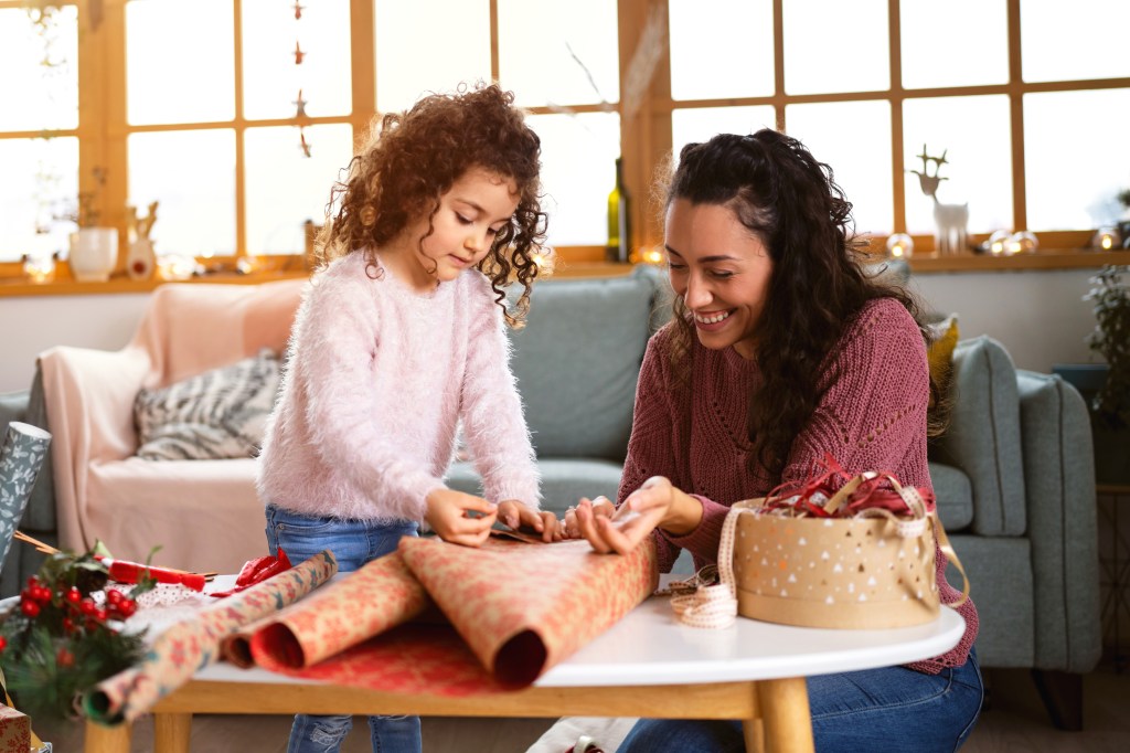 mother and daughter together, wrapping and decorating Christmas presents