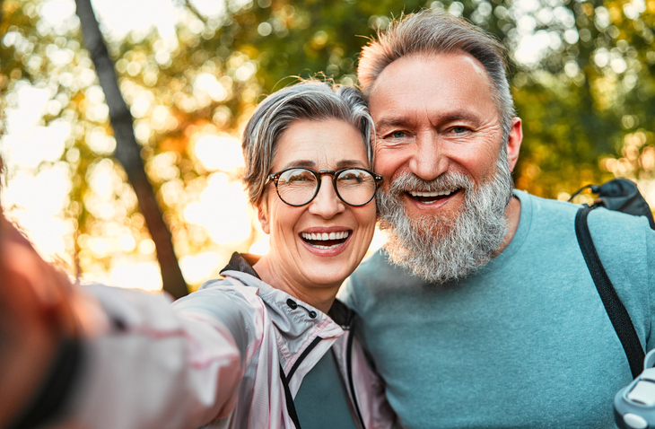 Today's active retirees are enjoying life. A man with a gray beard and a woman in glasses.