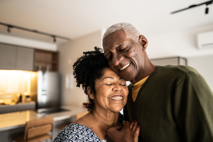 Senior couple embracing each other at home