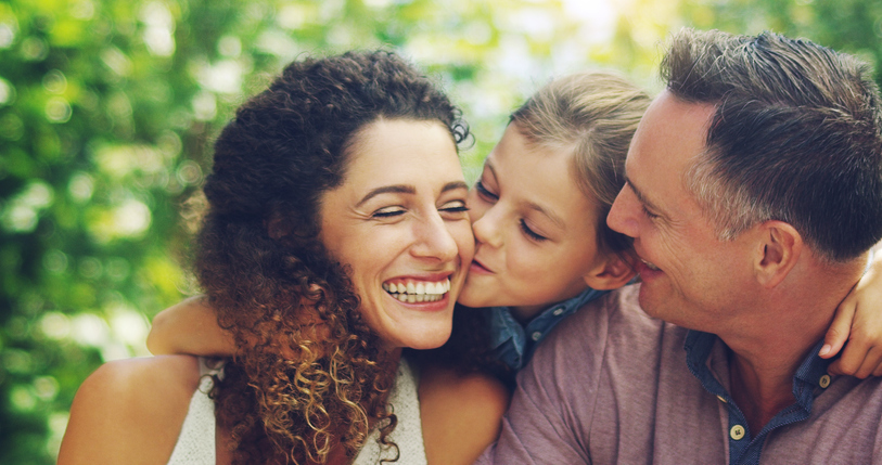 Shot of an affectionate little girl spending quality time with her mother and father outdoors