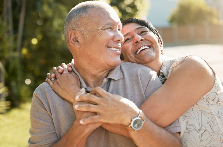 Love, hug and happy old couple in garden, laugh and marriage with retirement together in nature with trees. Funny outdoor embrace, senior man and woman in backyard to relax with romance and smile.